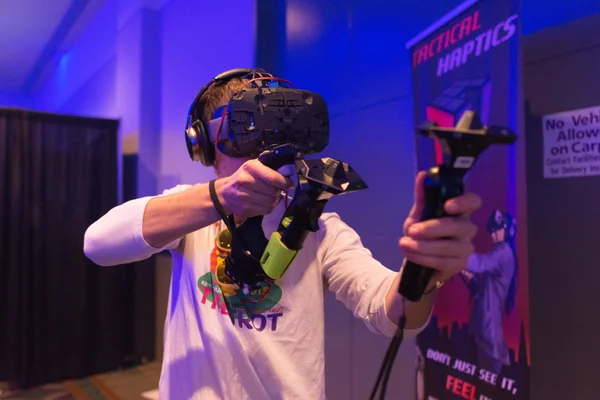 Man tries virtual reality HTC Vive headset and hand controls — Stock Fotó