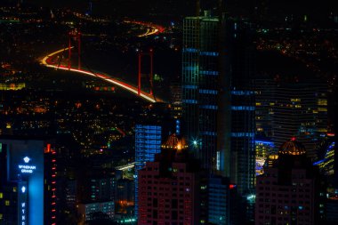İstanbul gece manzarası, yüksek binalar ve plazalar.