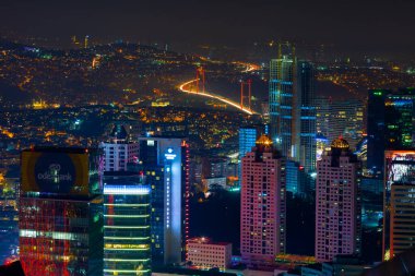 İstanbul gece manzarası, yüksek binalar ve plazalar.