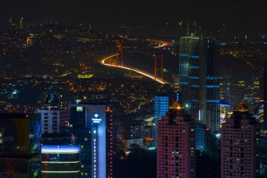 İstanbul gece manzarası, yüksek binalar ve plazalar.