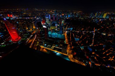 İstanbul gece manzarası, yüksek binalar ve plazalar.