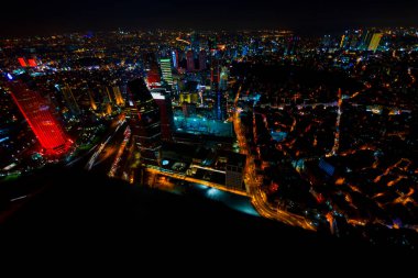 İstanbul gece manzarası, yüksek binalar ve plazalar.