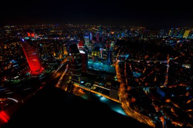 İstanbul gece manzarası, yüksek binalar ve plazalar.