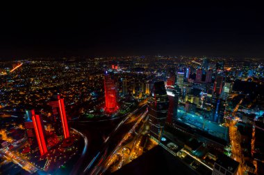 İstanbul gece manzarası, yüksek binalar ve plazalar.