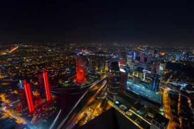 İstanbul gece manzarası, yüksek binalar ve plazalar.