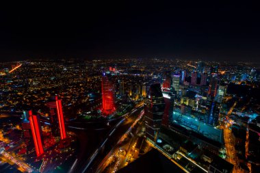 İstanbul gece manzarası, yüksek binalar ve plazalar.