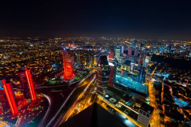 İstanbul gece manzarası, yüksek binalar ve plazalar.