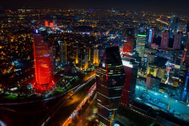 İstanbul gece manzarası, yüksek binalar ve plazalar.
