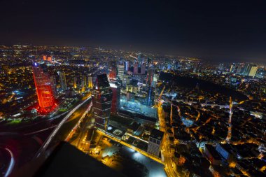 İstanbul gece manzarası, yüksek binalar ve plazalar.