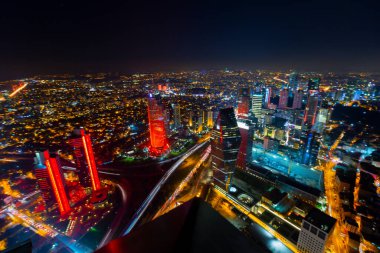 İstanbul gece manzarası, yüksek binalar ve plazalar.