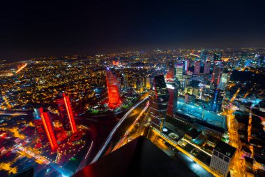 İstanbul gece manzarası, yüksek binalar ve plazalar.