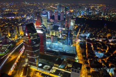İstanbul gece manzarası, yüksek binalar ve plazalar.