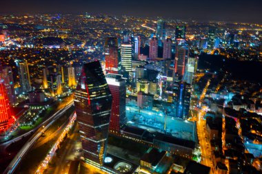 İstanbul gece manzarası, yüksek binalar ve plazalar.