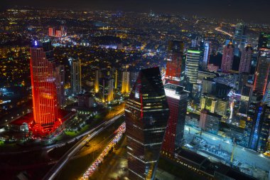 İstanbul gece manzarası, yüksek binalar ve plazalar.