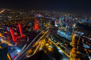 İstanbul gece manzarası, yüksek binalar ve plazalar.