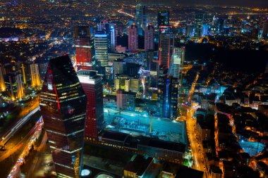 İstanbul gece manzarası, yüksek binalar ve plazalar.