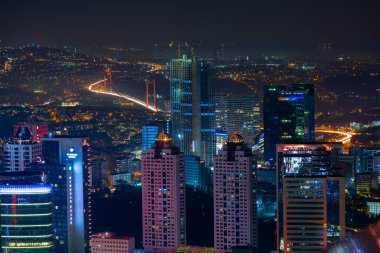 İstanbul gece manzarası, yüksek binalar ve plazalar.