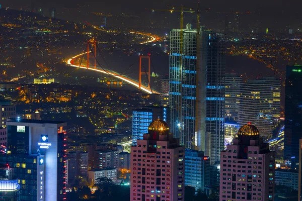 İstanbul gece manzarası, yüksek binalar ve plazalar.