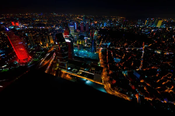 İstanbul gece manzarası, yüksek binalar ve plazalar.