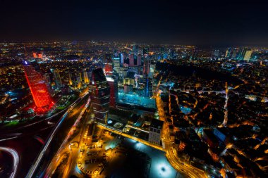 İstanbul gece manzarası, yüksek binalar ve plazalar.