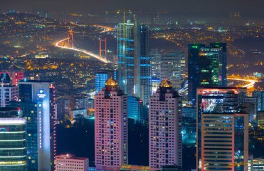 İstanbul gece manzarası, yüksek binalar ve plazalar.