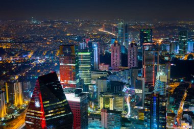 İstanbul gece manzarası, yüksek binalar ve plazalar.