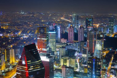 İstanbul gece manzarası, yüksek binalar ve plazalar.