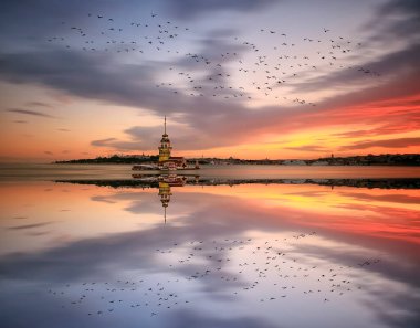 İstanbul, Türkiye 'nin sembolü Leander' s Tower olarak da bilinen ünlü Maiden 's Tower (Kiz Kulesi) ile Boğaz' ın üzerinde kızgın bir günbatımı. Duvar kağıdı veya rehber kitap için sahne yolculuğu arkaplanı