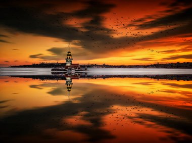 İstanbul, Türkiye 'nin sembolü Leander' s Tower olarak da bilinen ünlü Maiden 's Tower (Kiz Kulesi) ile Boğaz' ın üzerinde kızgın bir günbatımı. Duvar kağıdı veya rehber kitap için sahne yolculuğu arkaplanı