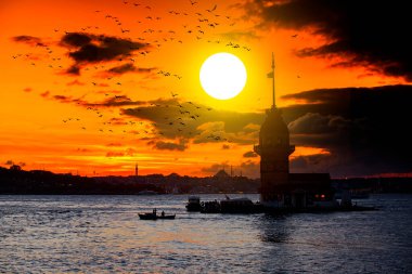İstanbul, Türkiye 'nin sembolü Leander' s Tower olarak da bilinen ünlü Maiden 's Tower (Kiz Kulesi) ile Boğaz' ın üzerinde kızgın bir günbatımı. Duvar kağıdı veya rehber kitap için sahne yolculuğu arkaplanı