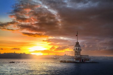 İstanbul, Türkiye 'nin sembolü Leander' s Tower olarak da bilinen ünlü Maiden 's Tower (Kiz Kulesi) ile Boğaz' ın üzerinde kızgın bir günbatımı. Duvar kağıdı veya rehber kitap için sahne yolculuğu arkaplanı