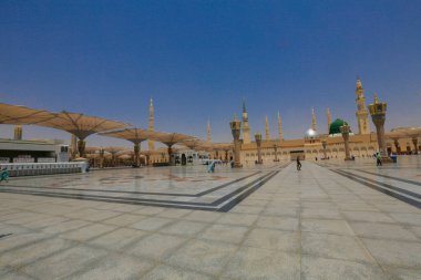 Medine Camii. Müslümanlar, Peygamber. Muhammed camisinin önünde büyük bir şemsiye altında oturdular. Medine, Suudi Arabistan