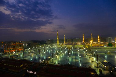 Medine Camii. Müslümanlar, Peygamber. Muhammed camisinin önünde büyük bir şemsiye altında oturdular. Medine, Suudi Arabistan