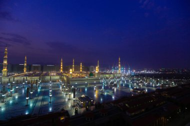 Medine Camii. Müslümanlar, Peygamber. Muhammed camisinin önünde büyük bir şemsiye altında oturdular. Medine, Suudi Arabistan
