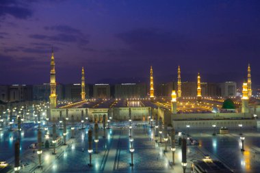 Medine Camii. Müslümanlar, Peygamber. Muhammed camisinin önünde büyük bir şemsiye altında oturdular. Medine, Suudi Arabistan