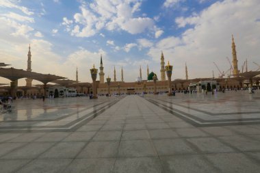 Medine Camii. Müslümanlar, Peygamber. Muhammed camisinin önünde büyük bir şemsiye altında oturdular. Medine, Suudi Arabistan