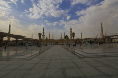 Medine Camii. Müslümanlar, Peygamber. Muhammed camisinin önünde büyük bir şemsiye altında oturdular. Medine, Suudi Arabistan