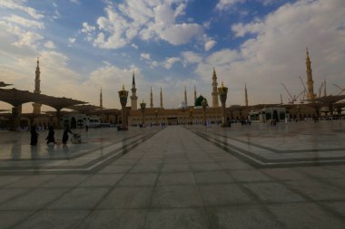 Medine Camii. Müslümanlar, Peygamber. Muhammed camisinin önünde büyük bir şemsiye altında oturdular. Medine, Suudi Arabistan