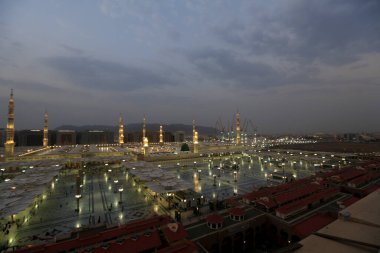 Medine Camii. Müslümanlar, Peygamber. Muhammed camisinin önünde büyük bir şemsiye altında oturdular. Medine, Suudi Arabistan