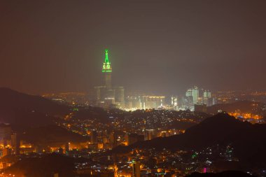 Abraj Al Bait Kraliyet Saat Kulesi ile Skyline Makkah, Suudi Arabistan. Kule, dünyanın en yüksek saat kulesidir. 601 metre 1972 metre yüksekliğindedir..