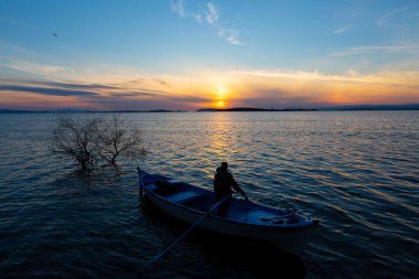 Gölde balık tutmak, gün batımı ve büyük gölde yaşayan insanlar..