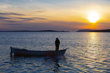 Gölde balık tutmak, gün batımı ve büyük gölde yaşayan insanlar..