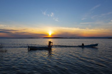 Gölde balık tutmak, gün batımı ve büyük gölde yaşayan insanlar..