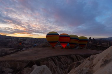Türkiye 'nin Kapadokya kentindeki sıradışı kayalık manzaraya yüzeysel bir bakış açısı. Kapadokya 'daki peri bacalarıyla mavi gökyüzünde renkli sıcak hava balonları uçuyor..