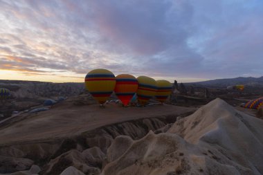 Türkiye 'nin Kapadokya kentindeki sıradışı kayalık manzaraya yüzeysel bir bakış açısı. Kapadokya 'daki peri bacalarıyla mavi gökyüzünde renkli sıcak hava balonları uçuyor..
