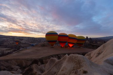 Türkiye 'nin Kapadokya kentindeki sıradışı kayalık manzaraya yüzeysel bir bakış açısı. Kapadokya 'daki peri bacalarıyla mavi gökyüzünde renkli sıcak hava balonları uçuyor..