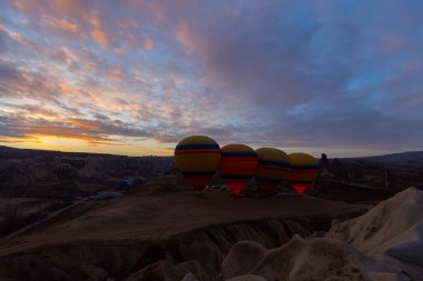Türkiye 'nin Kapadokya kentindeki sıradışı kayalık manzaraya yüzeysel bir bakış açısı. Kapadokya 'daki peri bacalarıyla mavi gökyüzünde renkli sıcak hava balonları uçuyor..