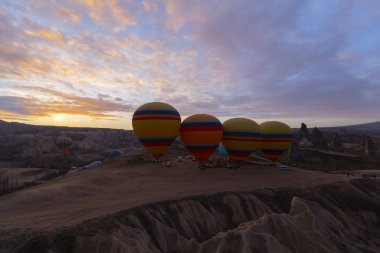 Türkiye 'nin Kapadokya kentindeki sıradışı kayalık manzaraya yüzeysel bir bakış açısı. Kapadokya 'daki peri bacalarıyla mavi gökyüzünde renkli sıcak hava balonları uçuyor..