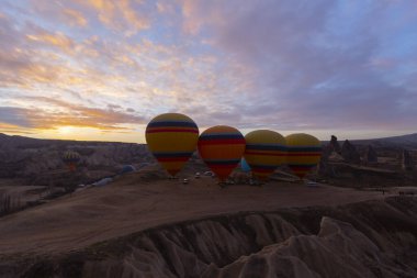 Türkiye 'nin Kapadokya kentindeki sıradışı kayalık manzaraya yüzeysel bir bakış açısı. Kapadokya 'daki peri bacalarıyla mavi gökyüzünde renkli sıcak hava balonları uçuyor..