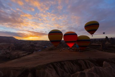 Türkiye 'nin Kapadokya kentindeki sıradışı kayalık manzaraya yüzeysel bir bakış açısı. Kapadokya 'daki peri bacalarıyla mavi gökyüzünde renkli sıcak hava balonları uçuyor..